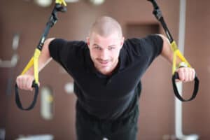 Man looking forward while using the trx suspension system.