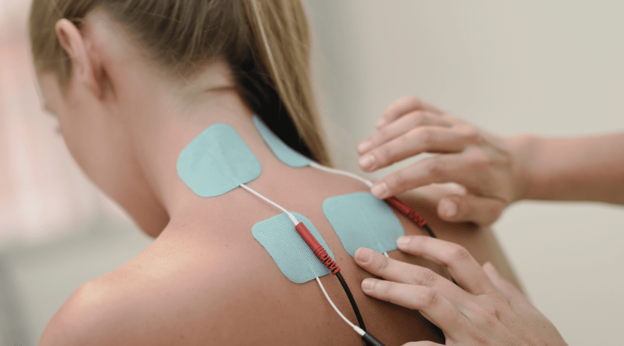 Electrical Stimulation Technique Chiropractor applying electrical stimulation therapy to relieve muscle pain and tension